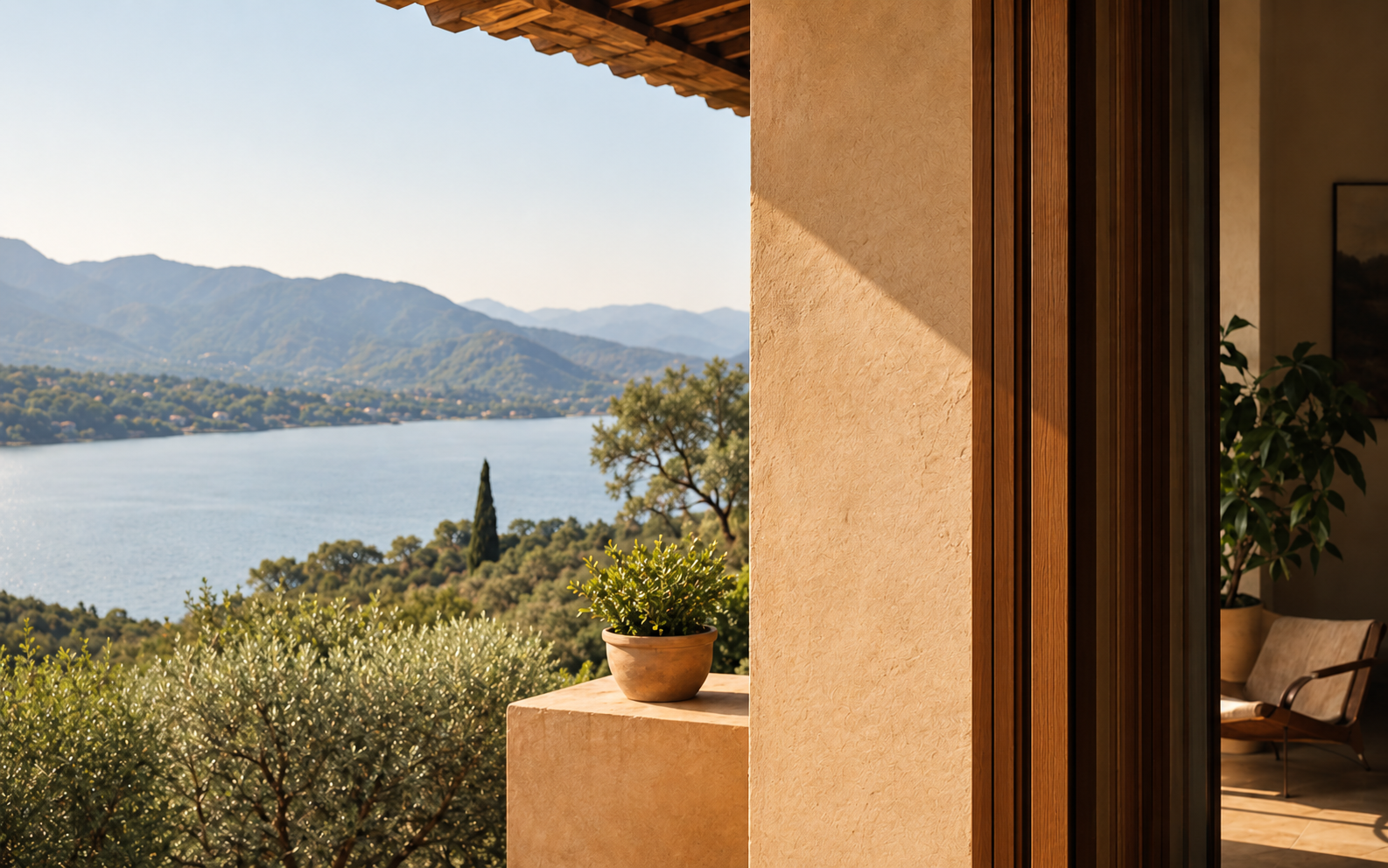 A warm architectural threshold opening onto a lake and mountain landscape